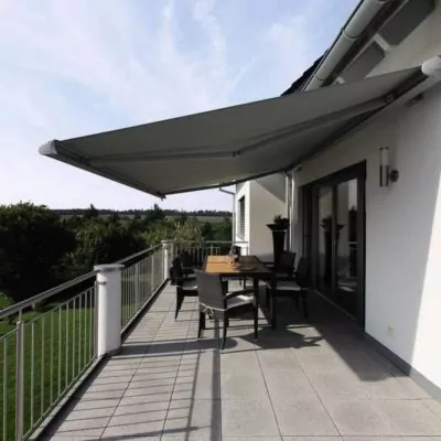 sonnenschutz-hainichen Großer Balkon mit ausgefahrener Markise als Sonnenschutz an einem modernen Wohnhaus.